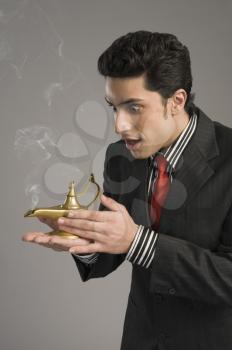 Close-up of a businessman scratching a magic lamp