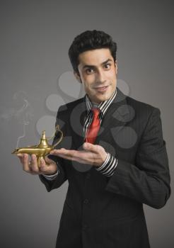 Portrait of a businessman holding a magic lamp