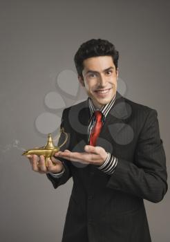 Portrait of a businessman holding a magic lamp