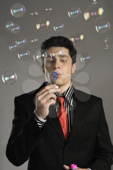 Businessman blowing bubbles
