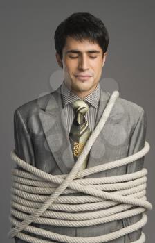 Close-up of a businessman tied up with ropes