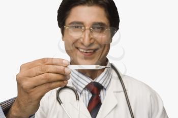 Portrait of a doctor holding a thermometer and smiling