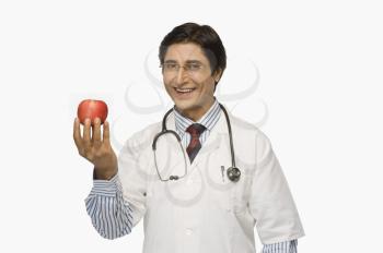 Portrait of a doctor holding an apple and smiling