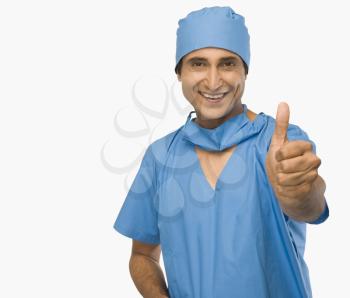 Portrait of a surgeon showing thumbs up and smiling