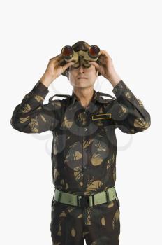 Army soldier looking through binoculars