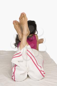 Woman lying on the bed and holding a remote control