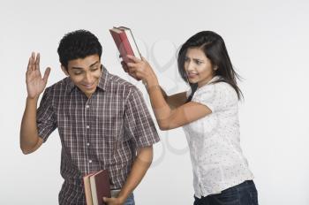 Woman beating her friend with a book