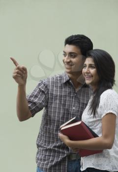 College students holding books and smiling