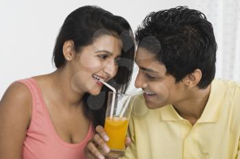 Couple sharing juice from a glass