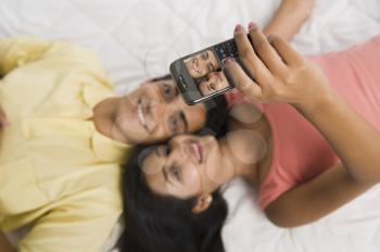 Close-up of a couple taking a picture of themselves with a camera phone