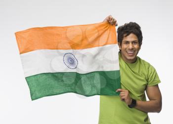 Portrait of a man holding aloft an Indian flag