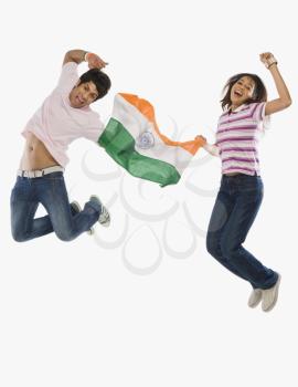 Couple holding Indian flag and jumping