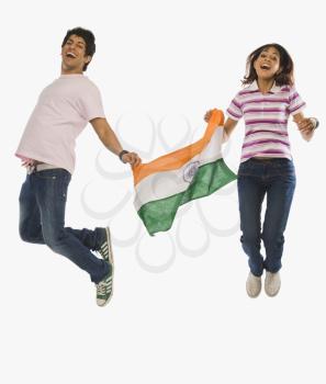 Couple holding Indian flag and jumping