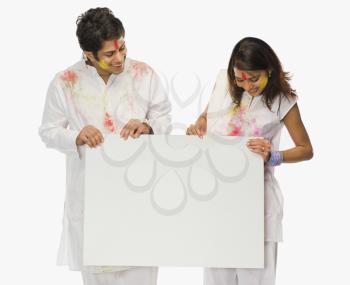 Couple holding a placard on Holi