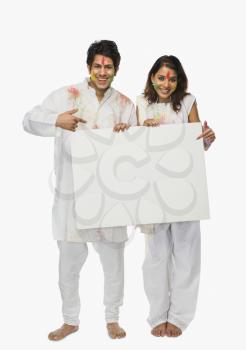 Couple holding a placard on Holi