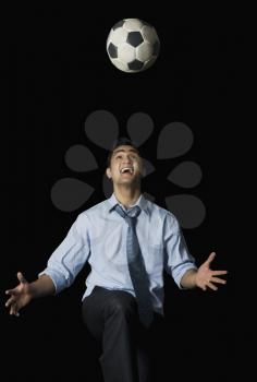 Businessman playing with a soccer ball