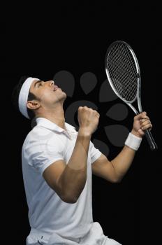 Tennis player celebrating with his arms raised