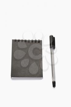 Close-up of a pen with a spiral notebook