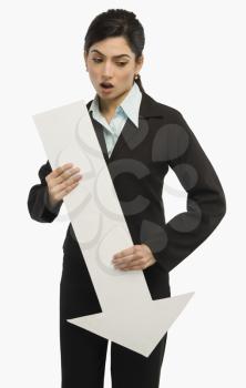 Businesswoman holding a downward arrow sign