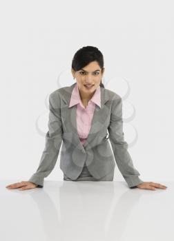 Portrait of a businesswoman leaning on a desk