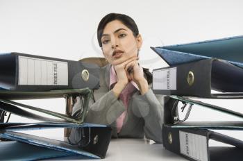 Stack of ring binders in front of a businesswoman