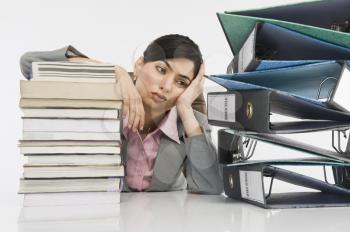 Stack of books in front of a businesswoman at desk