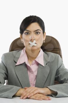 Businesswoman with adhesive tape over her mouth