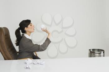Businesswoman throwing crumpled paper into a wastepaper basket