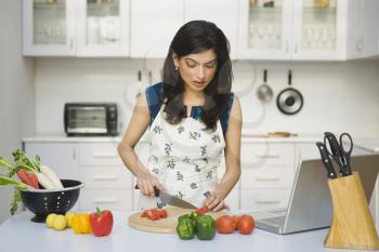 Woman chopping tomatoes in the kitchen