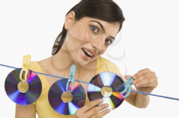Woman hanging CDs on a clothesline