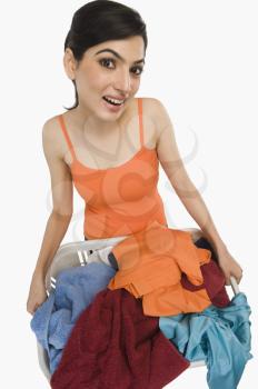 Woman holding laundry basket filled with clothing