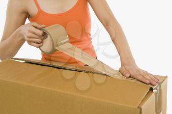 Woman packing cardboard by packing tape