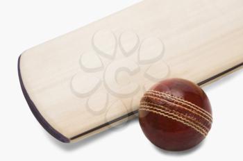 Close-up of a cricket ball with a bat