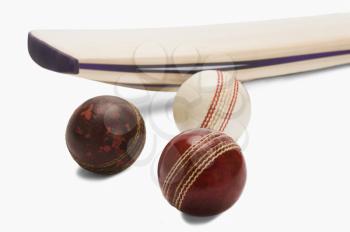 Close-up of cricket balls with a bat