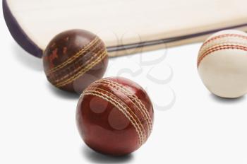 Close-up of cricket balls with a bat