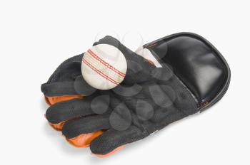Close-up of a cricket ball on a wicket keeping glove