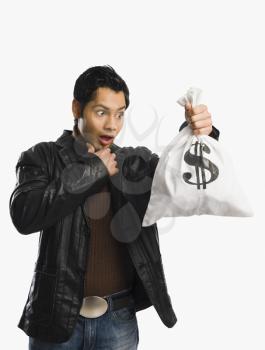 Man holding a money bag and looking surprised