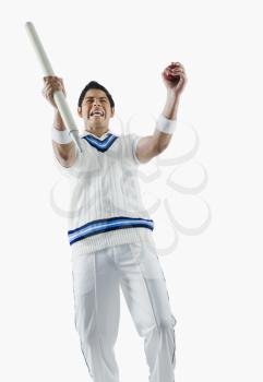 Cricket bowler cheering with a cricket ball and stump