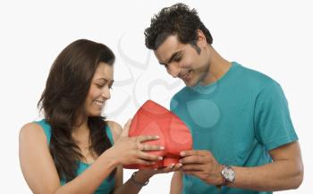 Couple holding a heart shape gift