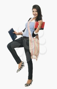 University student holding books and smiling