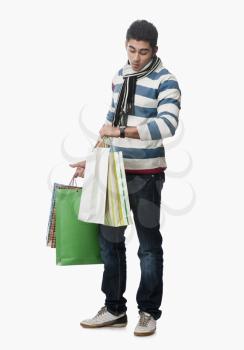 Man checking the time and carrying shopping bags