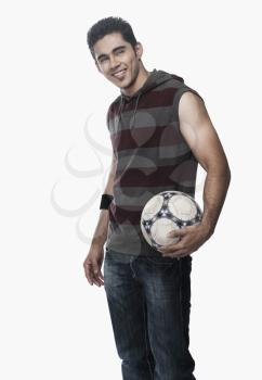 Man holding a soccer ball and looking away