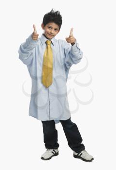 Boy dressed as a businessman and pointing gun sign