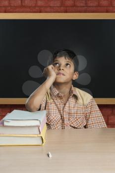 Boy imitating a teacher in a classroom and thinking