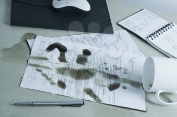 Spilt coffee over documents on a desk