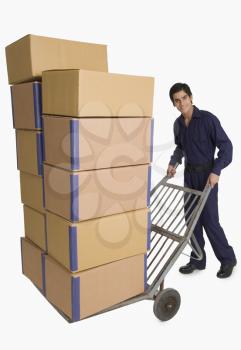 Storekeeper carrying cardboard boxes on a hand truck