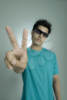 Close-up of a man showing peace sign