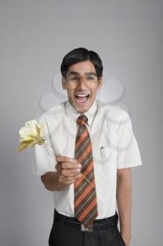 Man holding a flower and looking shocked