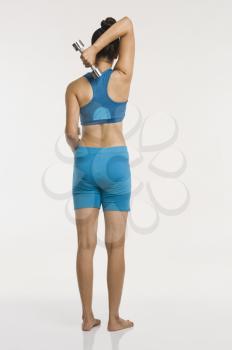 Rear view of a woman exercising with dumbbells
