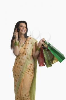 Woman talking on a mobile phone and holding shopping bags